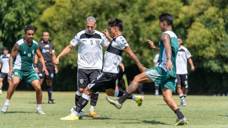 Players in action during a competitive soccer match outdoors in a lush green field.