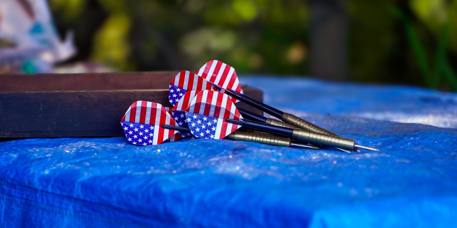 Darts with American flag pattern on a blue table, outdoors in Kodaikanal, India.