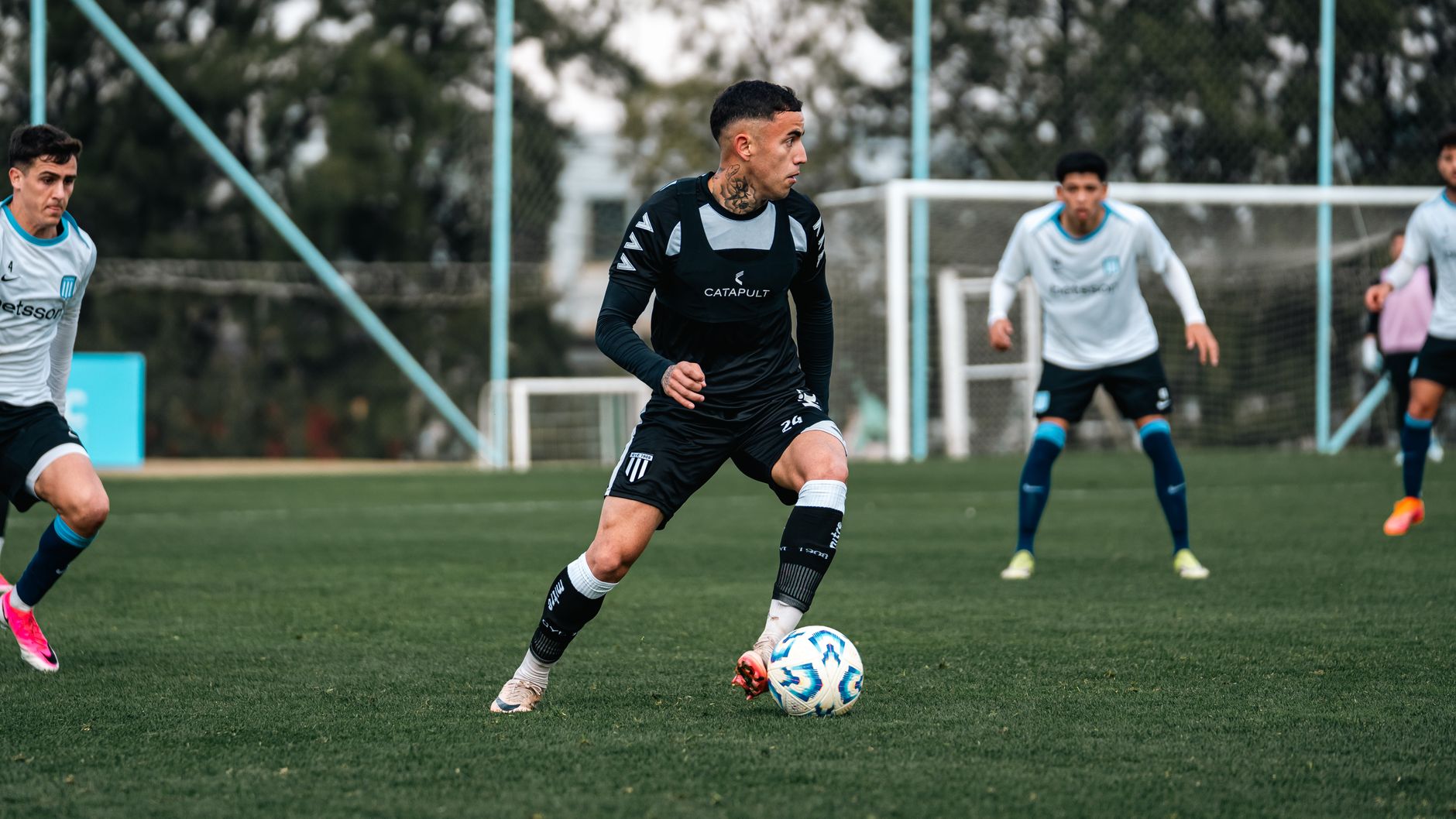 Soccer players in action during a competitive match on a grass field.