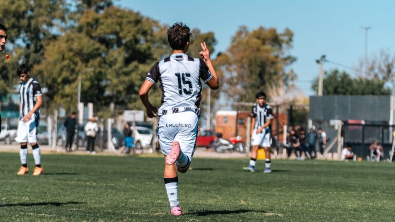 Young soccer player celebrates during a match on a sunny day outdoors.