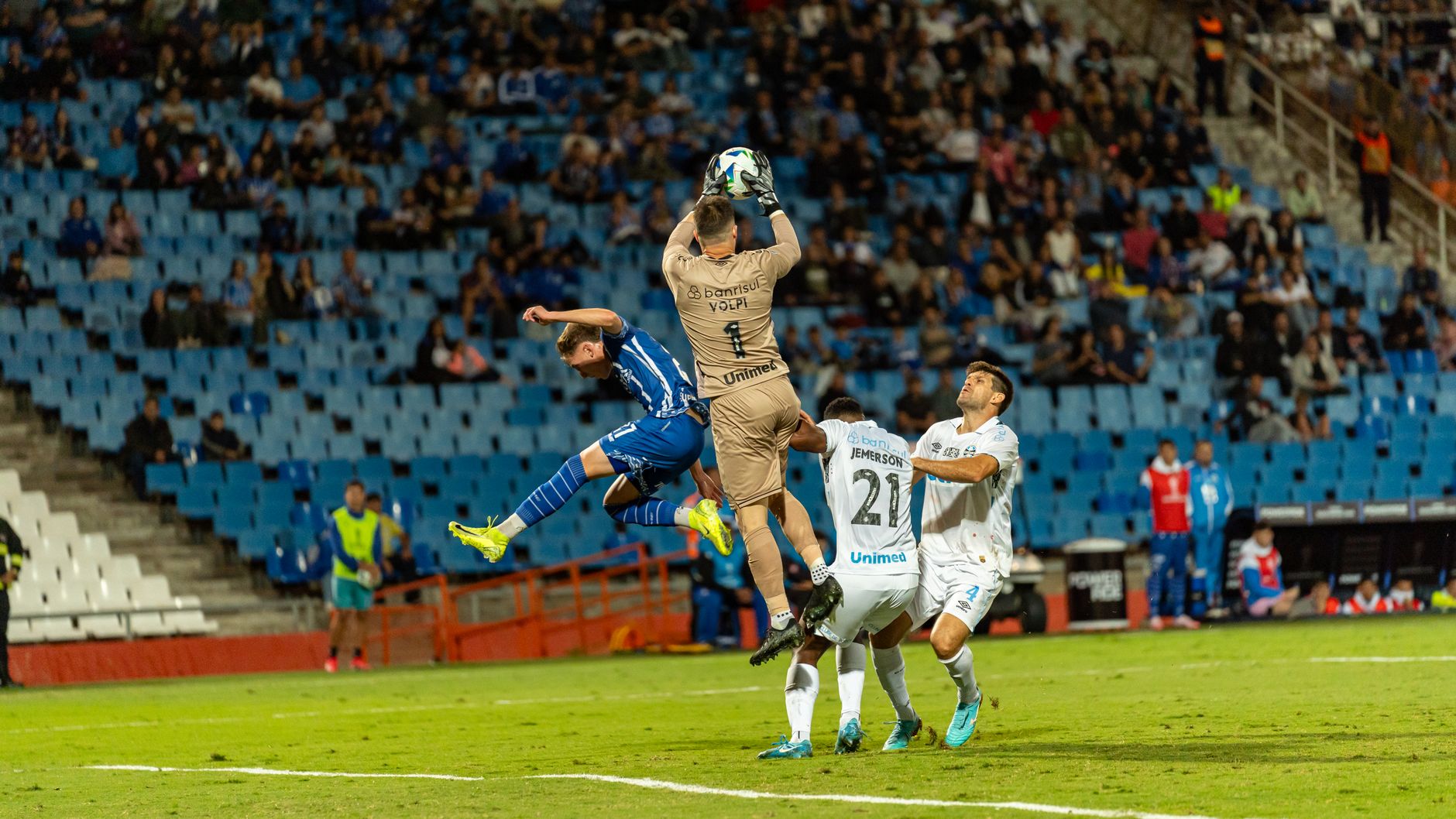 Football players in action during an intense match, capturing a dynamic stadium scene.
