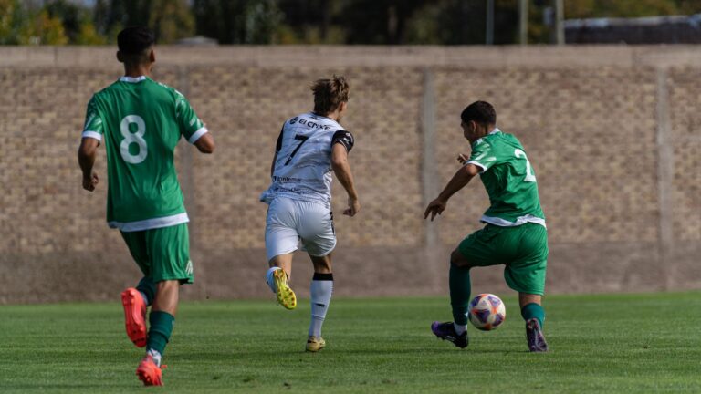 Dynamic action shot of three players competing in an outdoor soccer match.