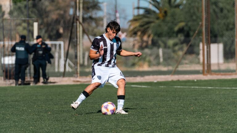 Dynamic shot of a young adult playing soccer outdoors under clear sky.