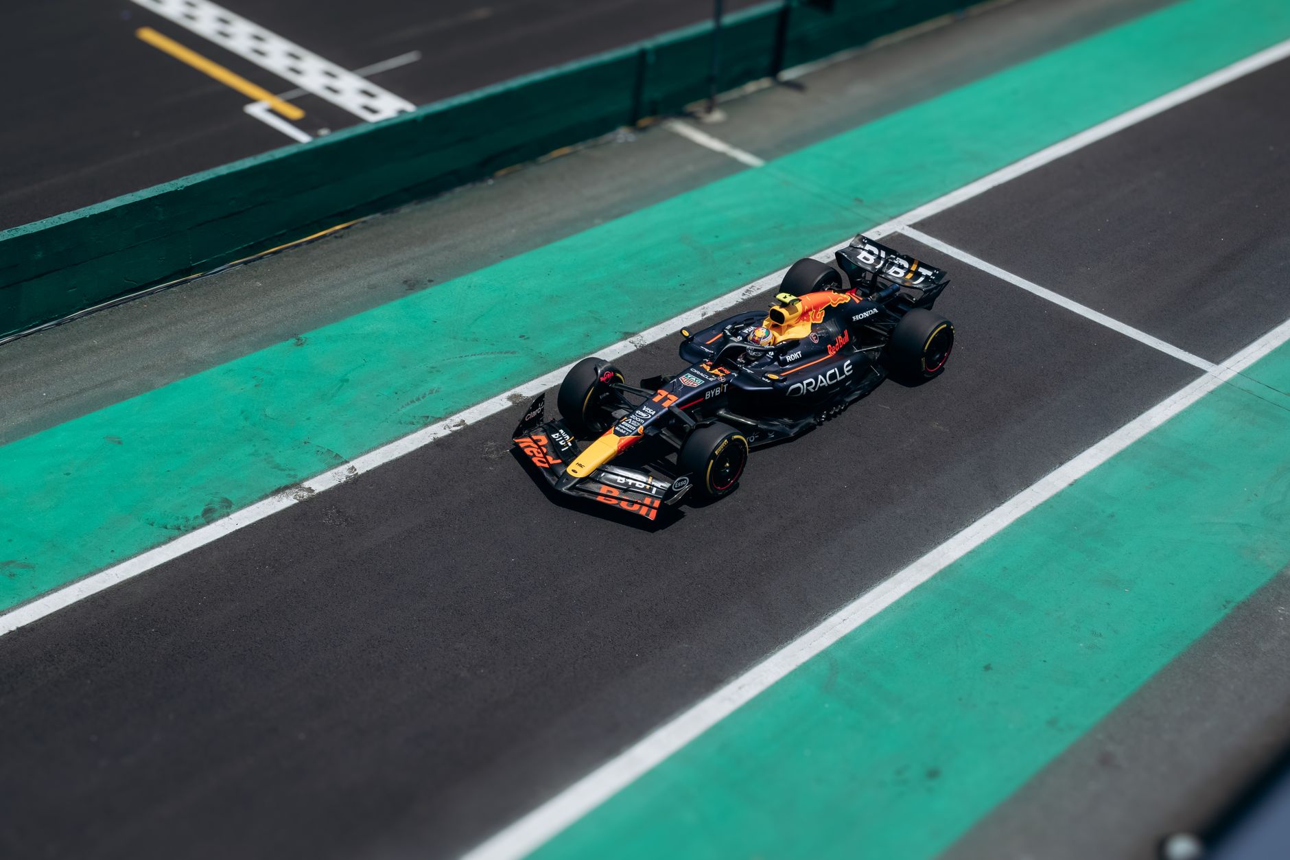 High-angle shot of a Formula One race car speeding on the track during a sunny day.