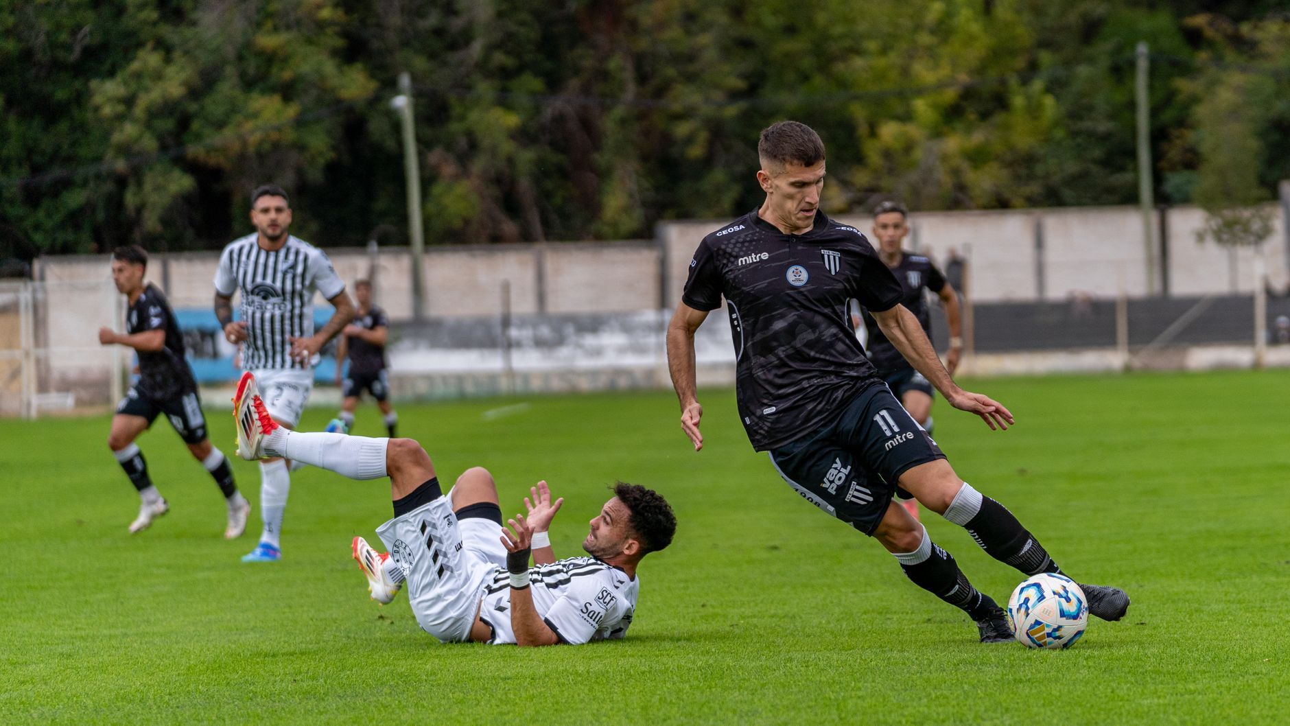 Dramatic moment in an outdoor soccer match capturing player action and dynamic movement.