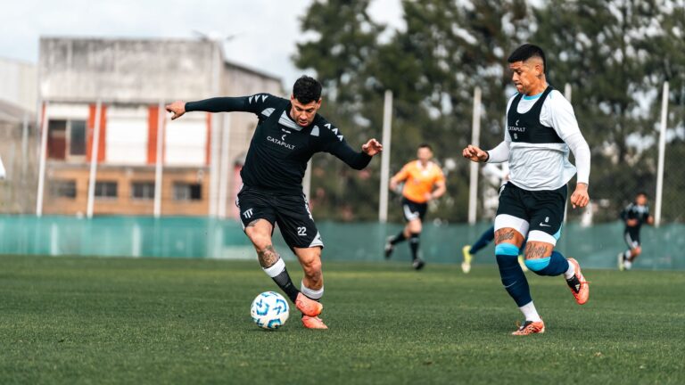 Two soccer players in mid-action during a competitive training session outdoors.