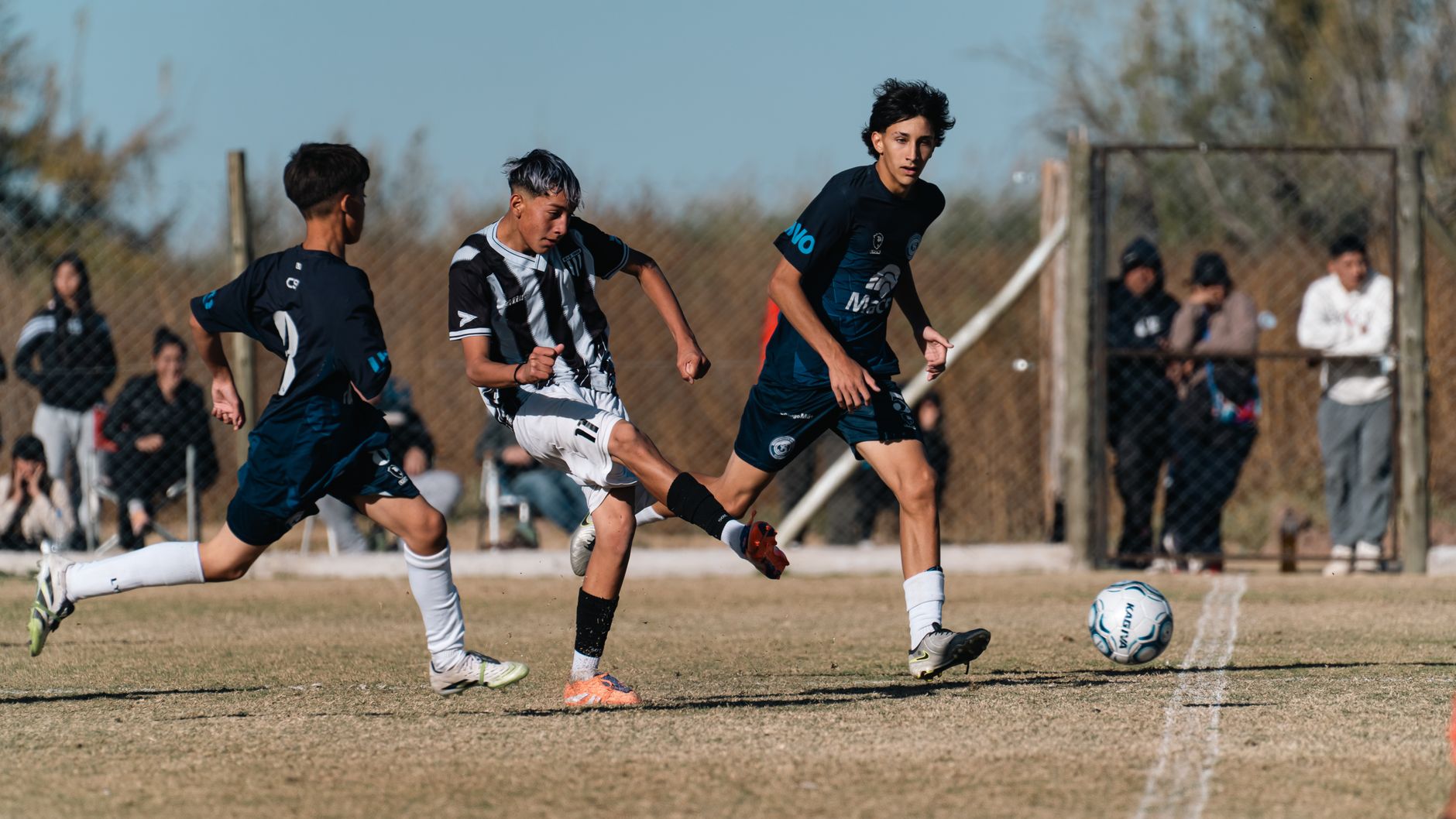 Intense moment from a youth soccer match with players in motion on a grassy field.