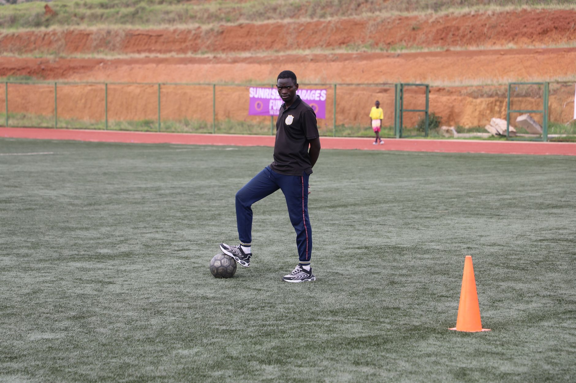 Soccer coach on field preparing for training with a focus on skill development.