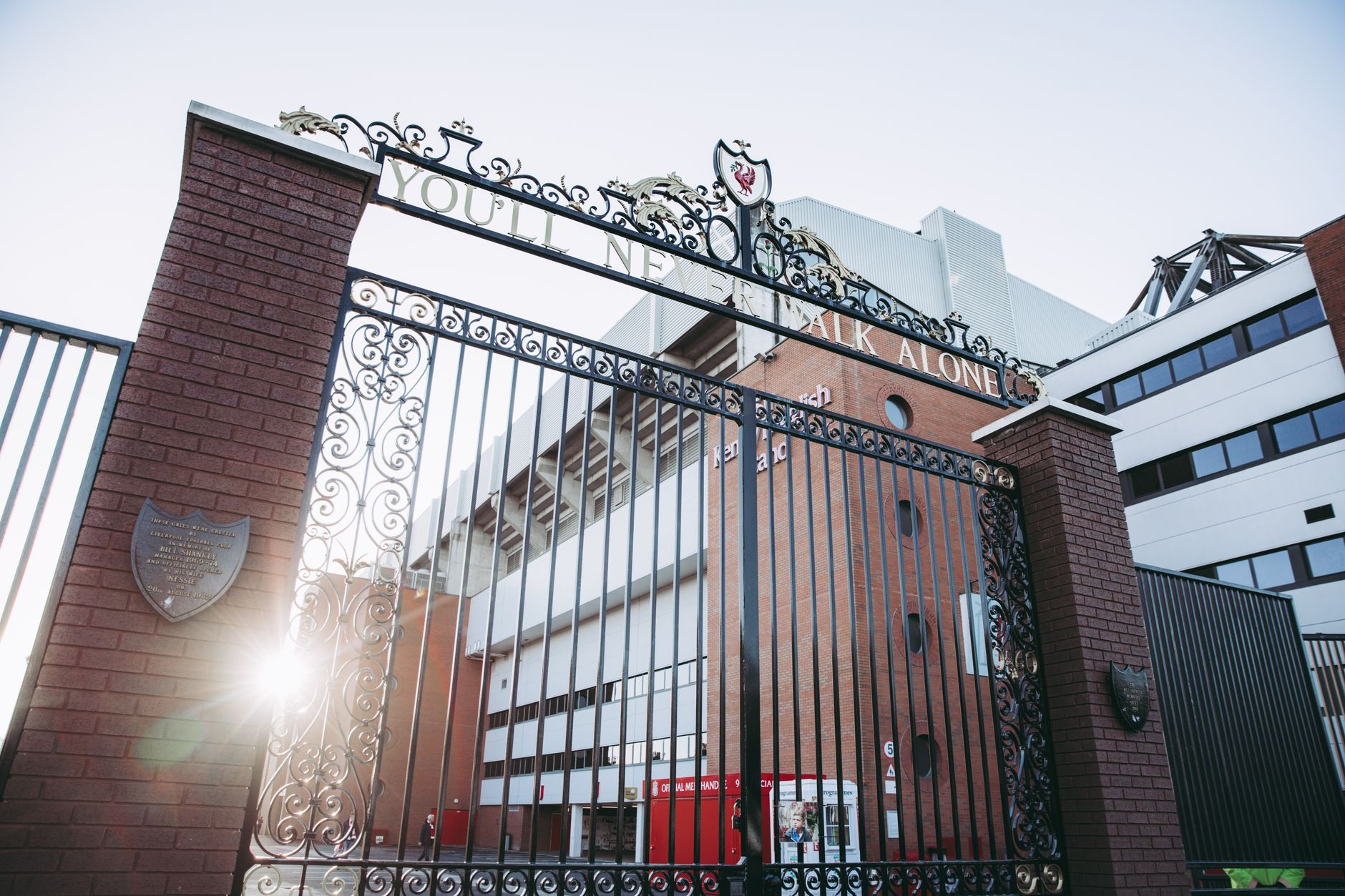 A photo capturing the iconic gates of Anfield Stadium, Liverpool, with sunrays illuminating the architecture.