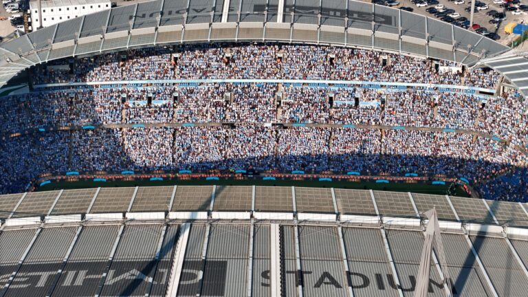 Aerial shot of Etihad Stadium filled with soccer fans in Manchester, UK.