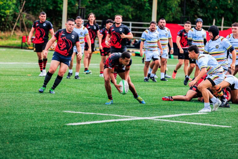 Players in action during a competitive rugby match on a green field.
