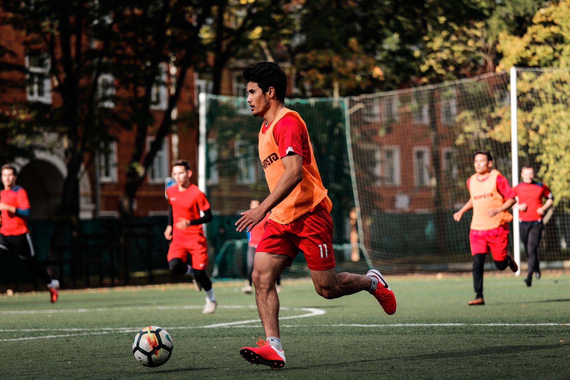 Young athletes playing a competitive soccer match outdoors in a Moscow park.