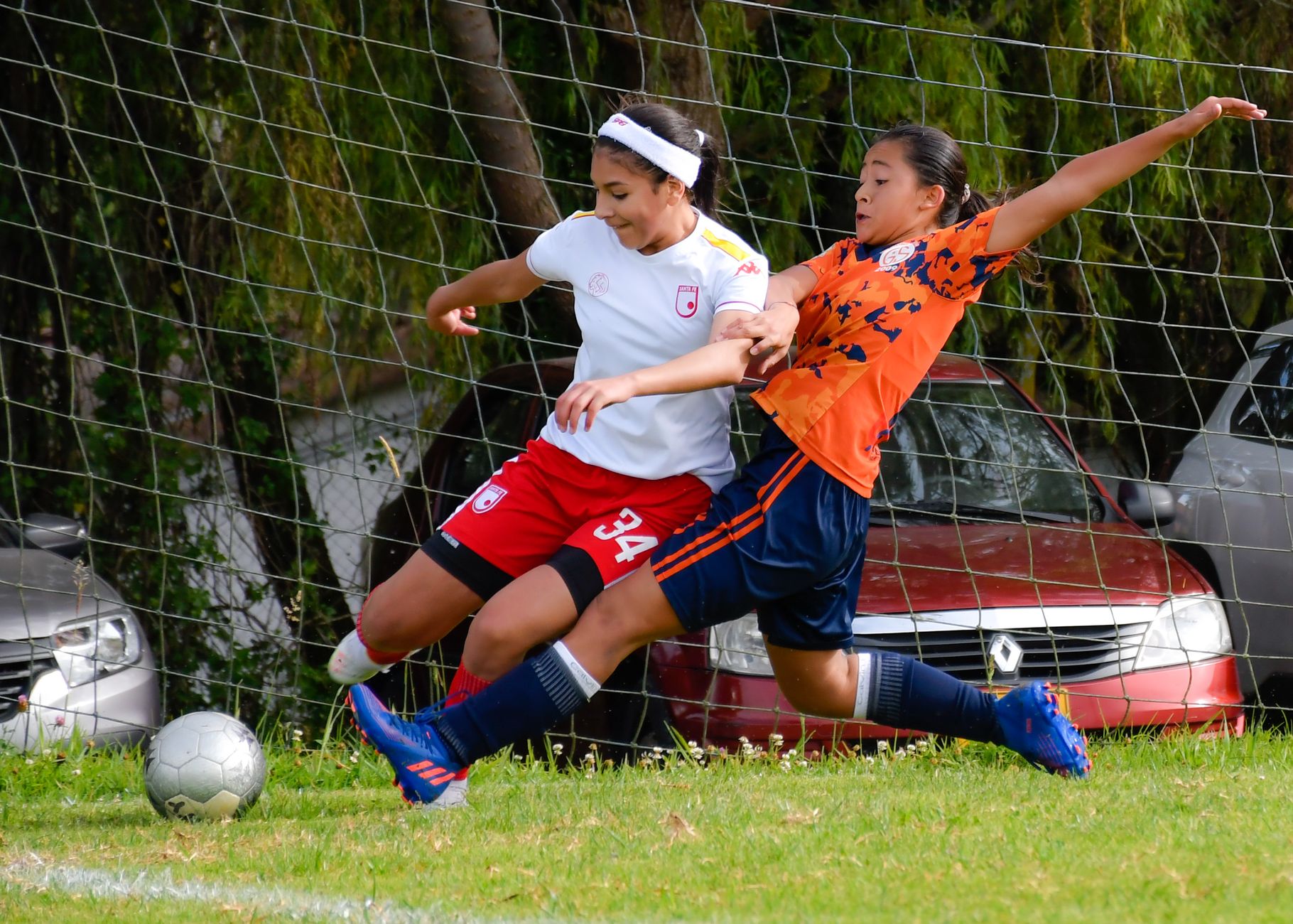 Dynamic image capturing two female soccer players in action during a game, showcasing teamwork and competition.