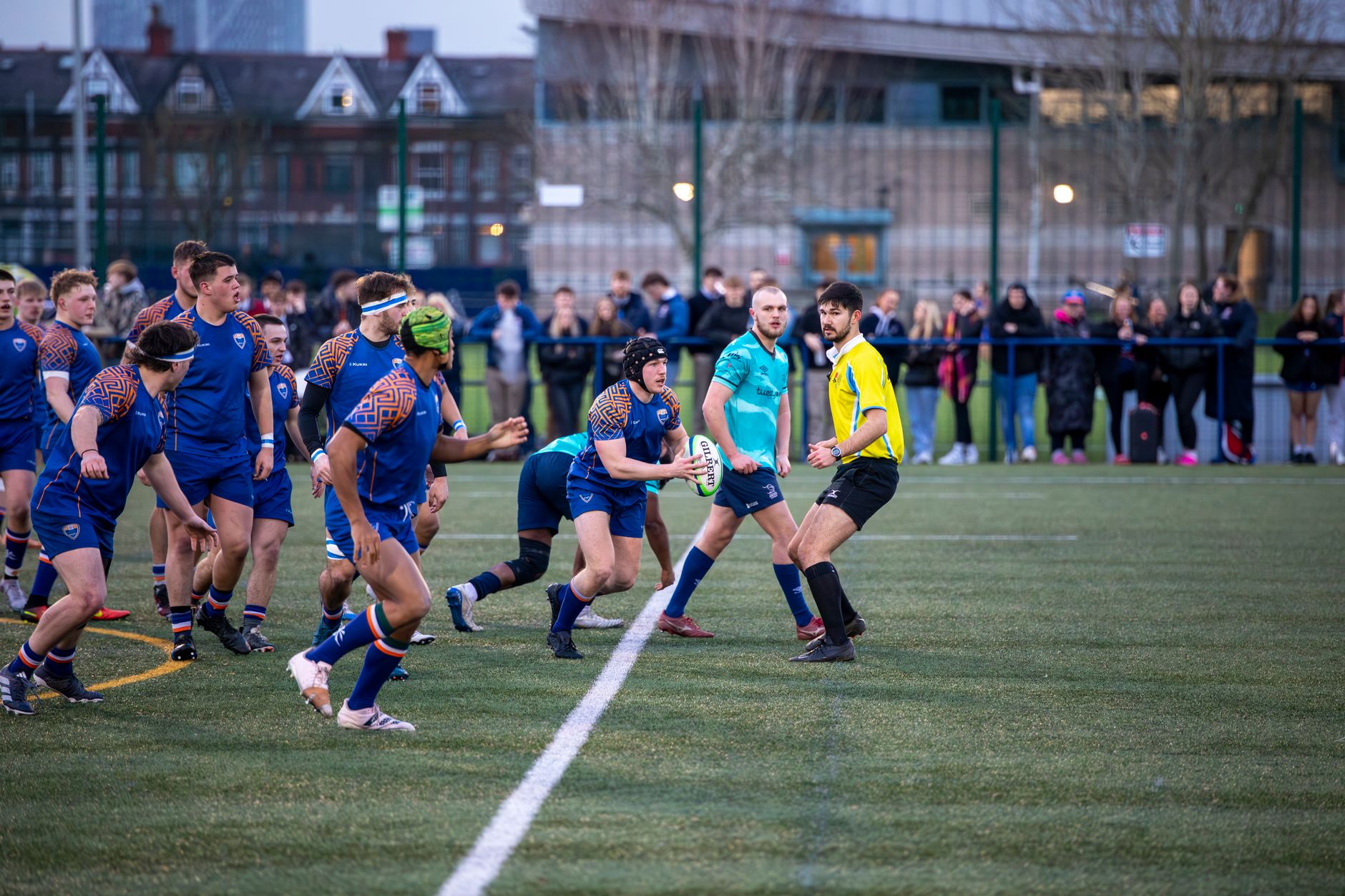 Vibrant rugby game with teams competing on a field in Manchester, England.