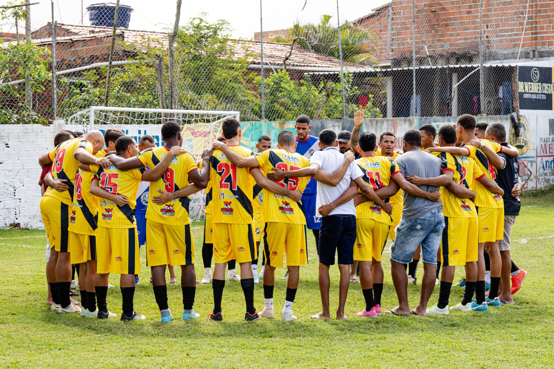 Amateur soccer players huddle on the field, preparing for their match with motivational energy and teamwork.
