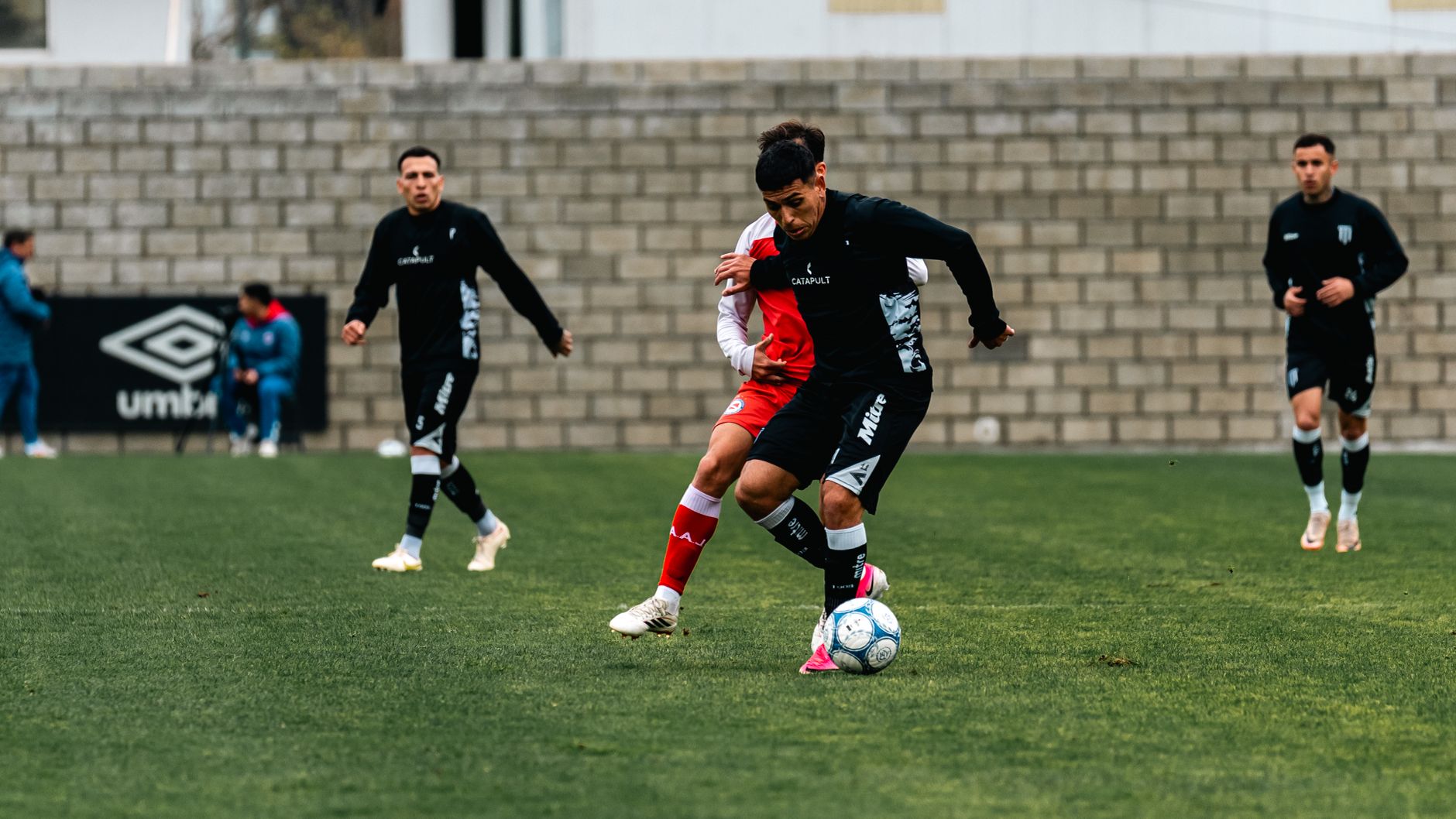 Dynamic soccer match featuring players in action on a well-maintained grass field.