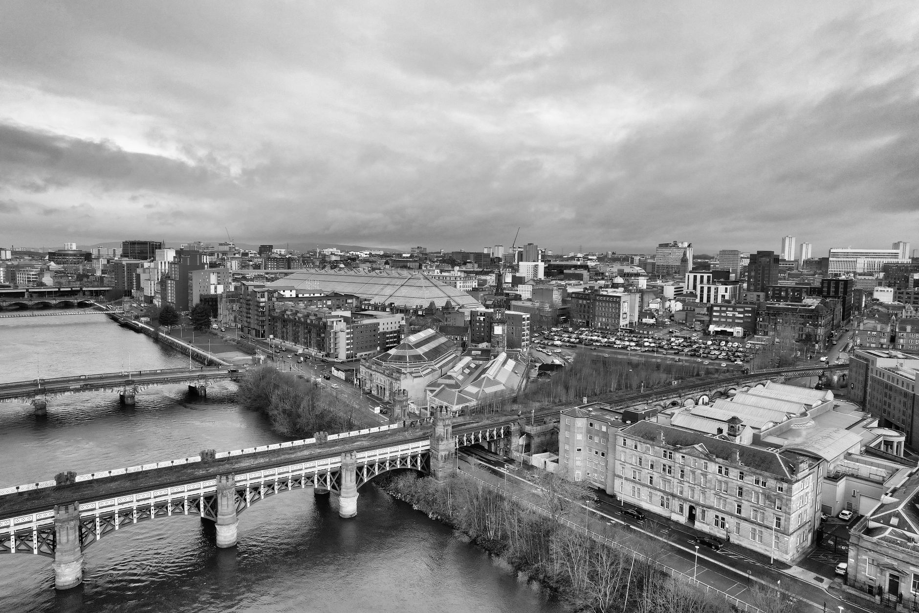 Aerial black and white cityscape of Glasgow, showcasing the River Clyde and iconic architecture.