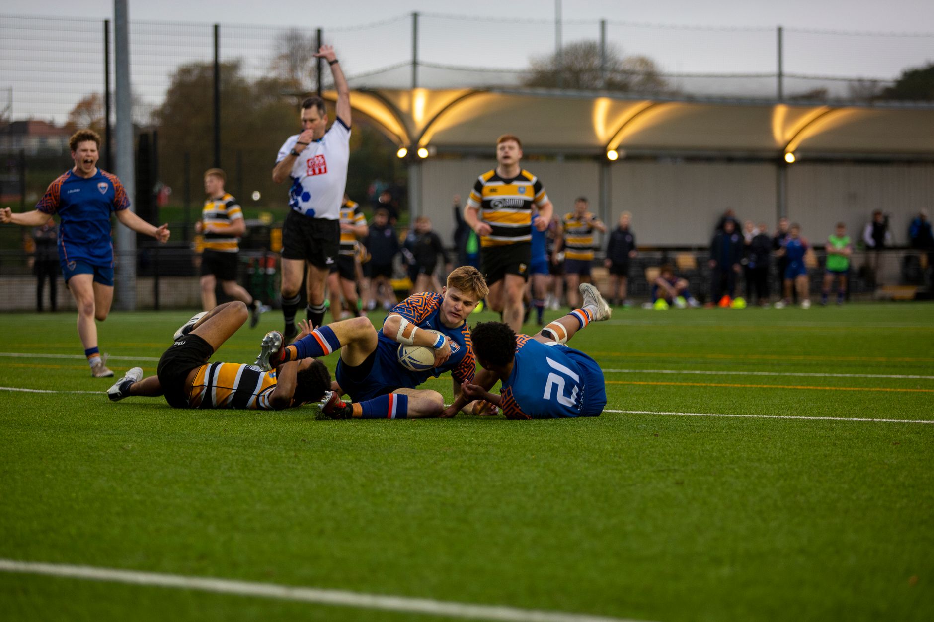 Intense action during a university rugby match on a green field.