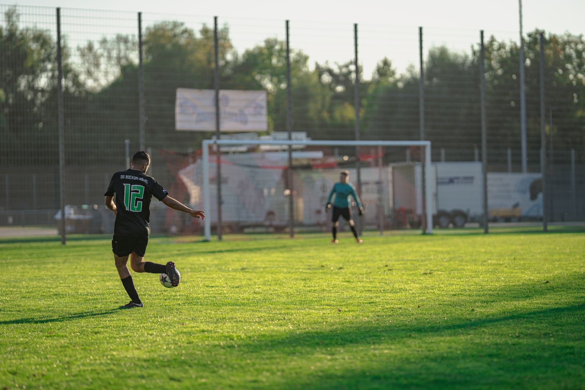 Captured moment of a soccer player taking a shot on goal during an outdoor match.