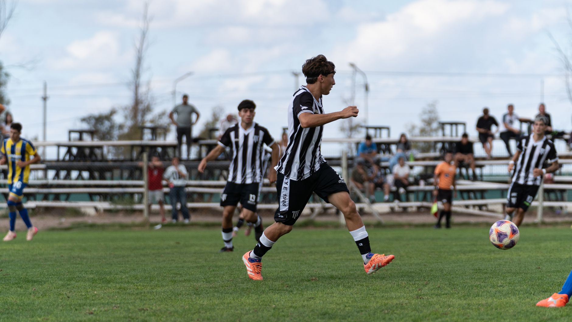 Young soccer players compete on a grass field during a match, showcasing teamwork and athleticism.