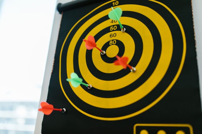 Vibrant darts stuck in a yellow and black dartboard representing precision and strategy.