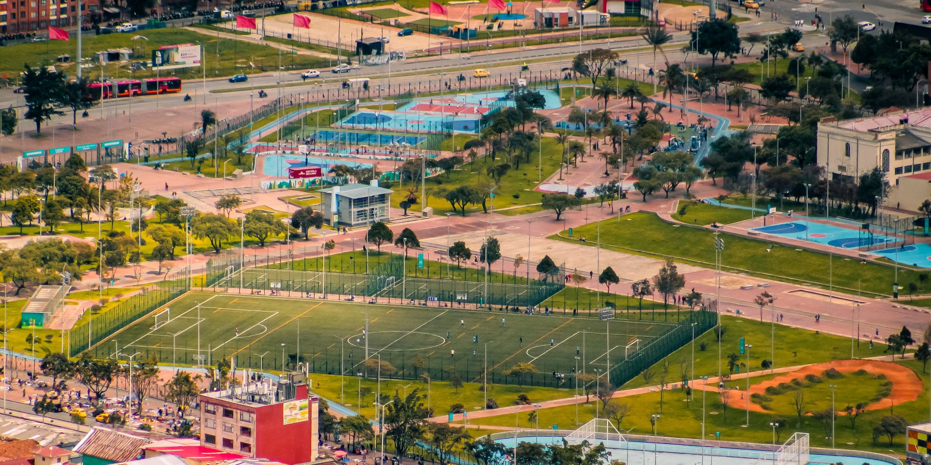 A vibrant aerial image of a sports complex with soccer fields and parks bustling with activity.