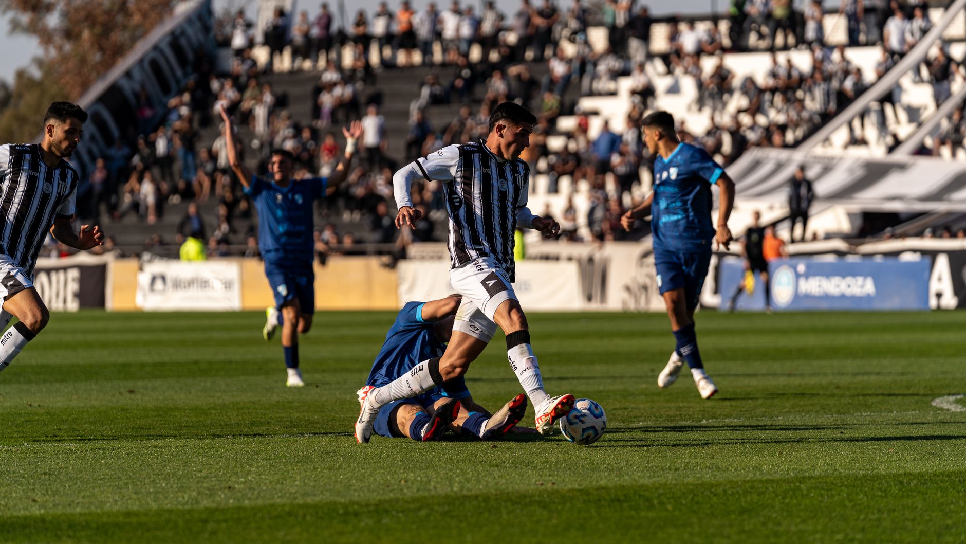 Action-packed soccer game with athletes competing intensely outdoors during the day.