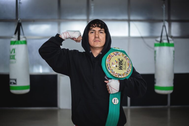 Champion boxer posing with WBC belt in Buenos Aires training gym.