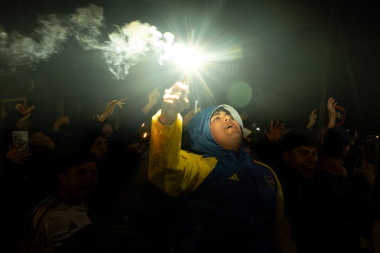 Vibrant night celebration as sports fans cheer with flares, capturing exhilarating crowd energy.