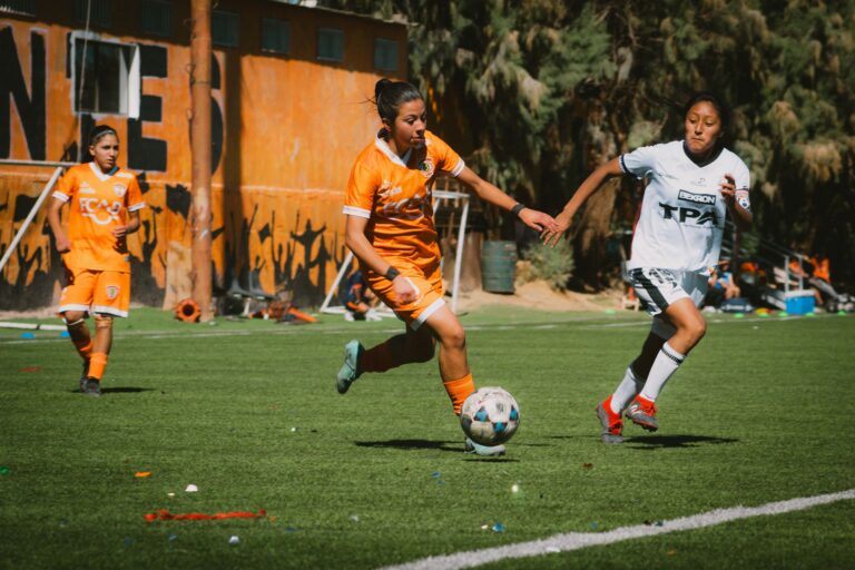 Exciting women's football match with players in action on a sunny day in Chile.