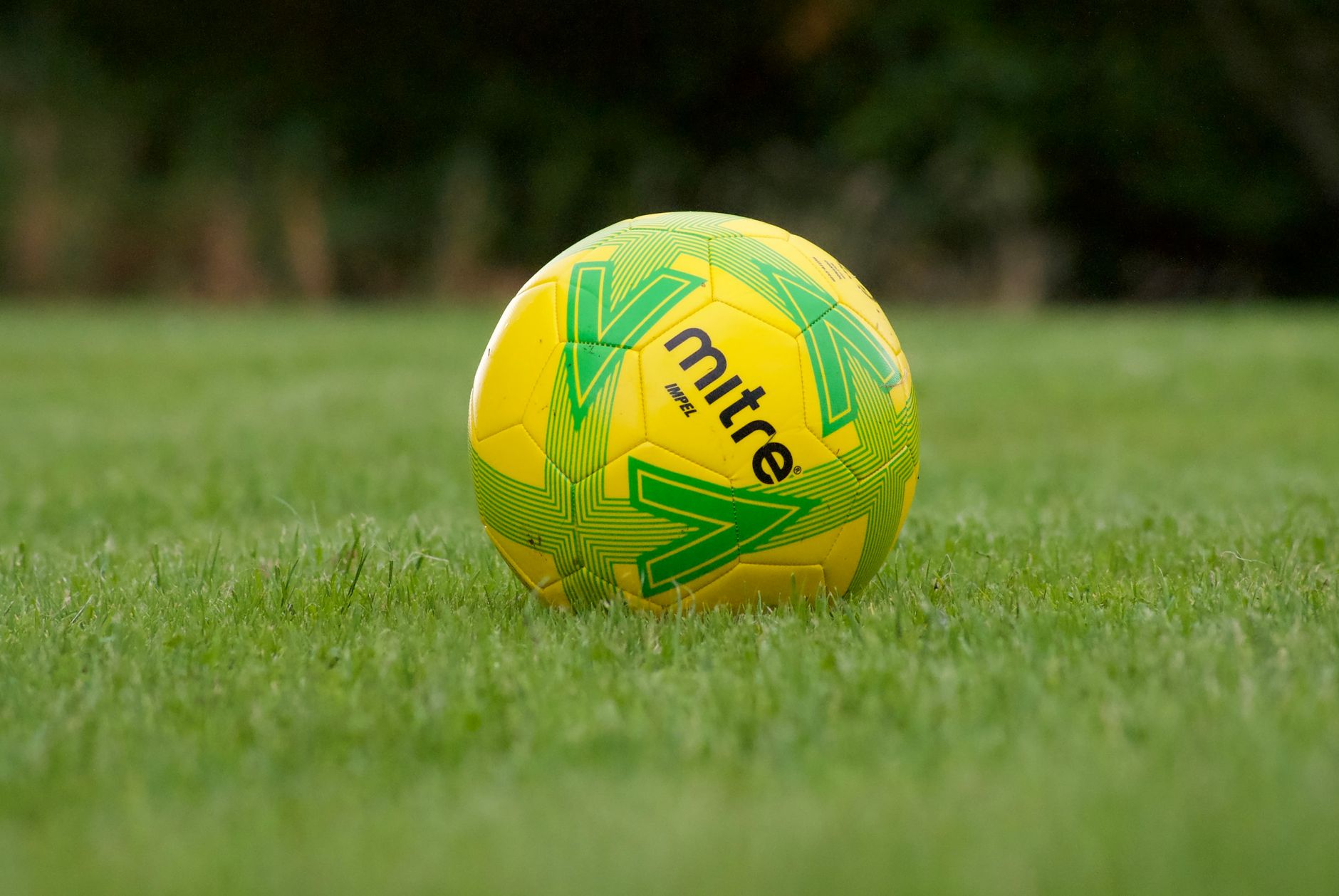 Vibrant yellow soccer ball on green grass, perfect for sports themes and outdoor activities.
