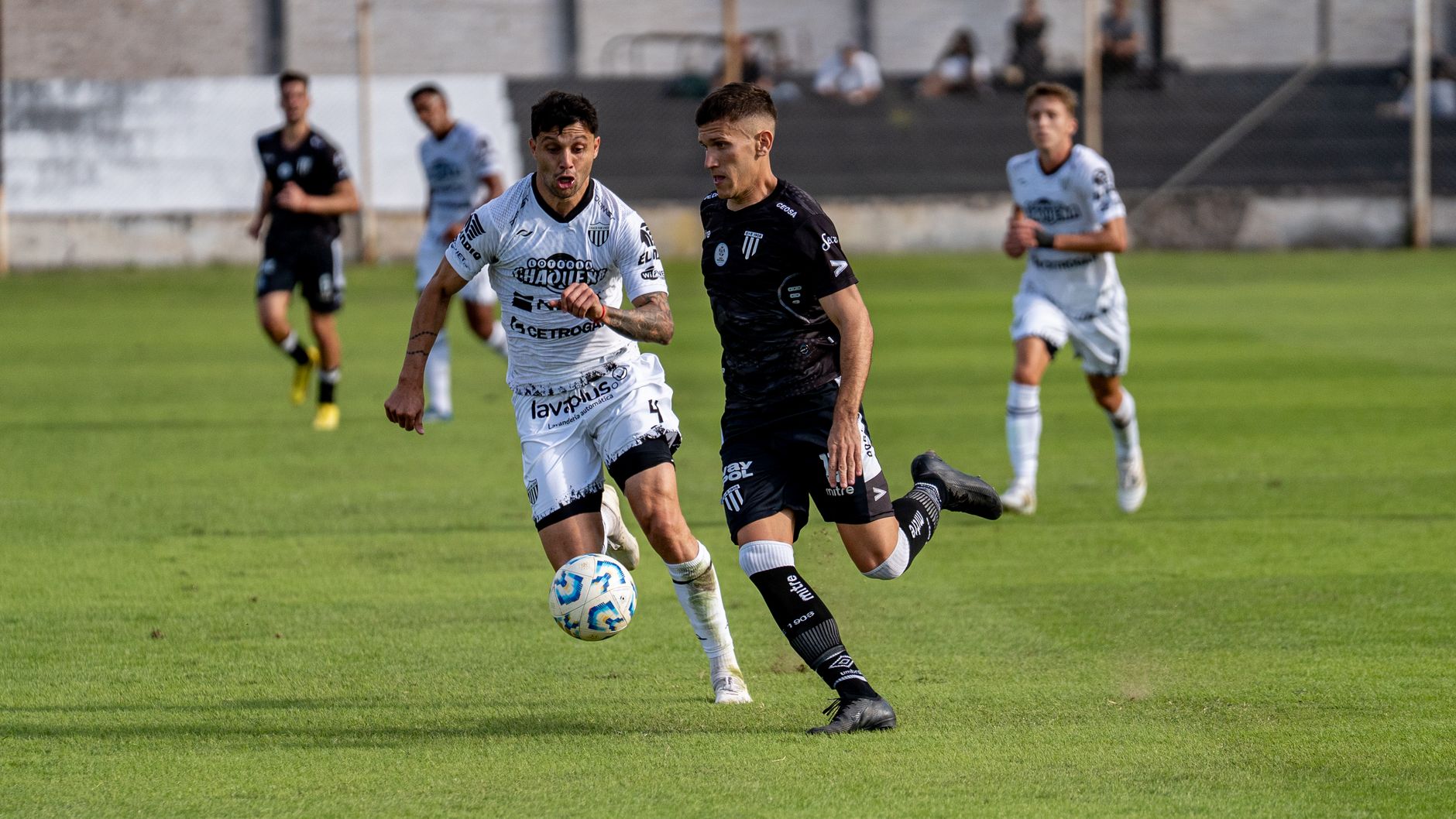 Two soccer players competing intensely during a match at a stadium.