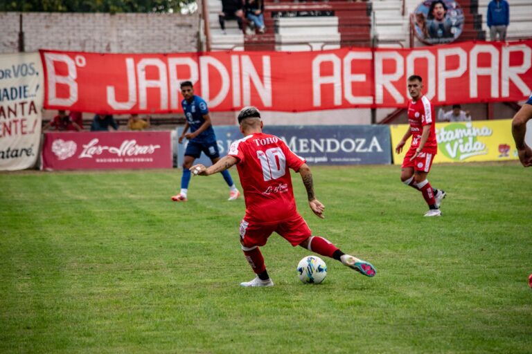 Action-packed soccer game with players in red and blue jerseys on a grassy field.